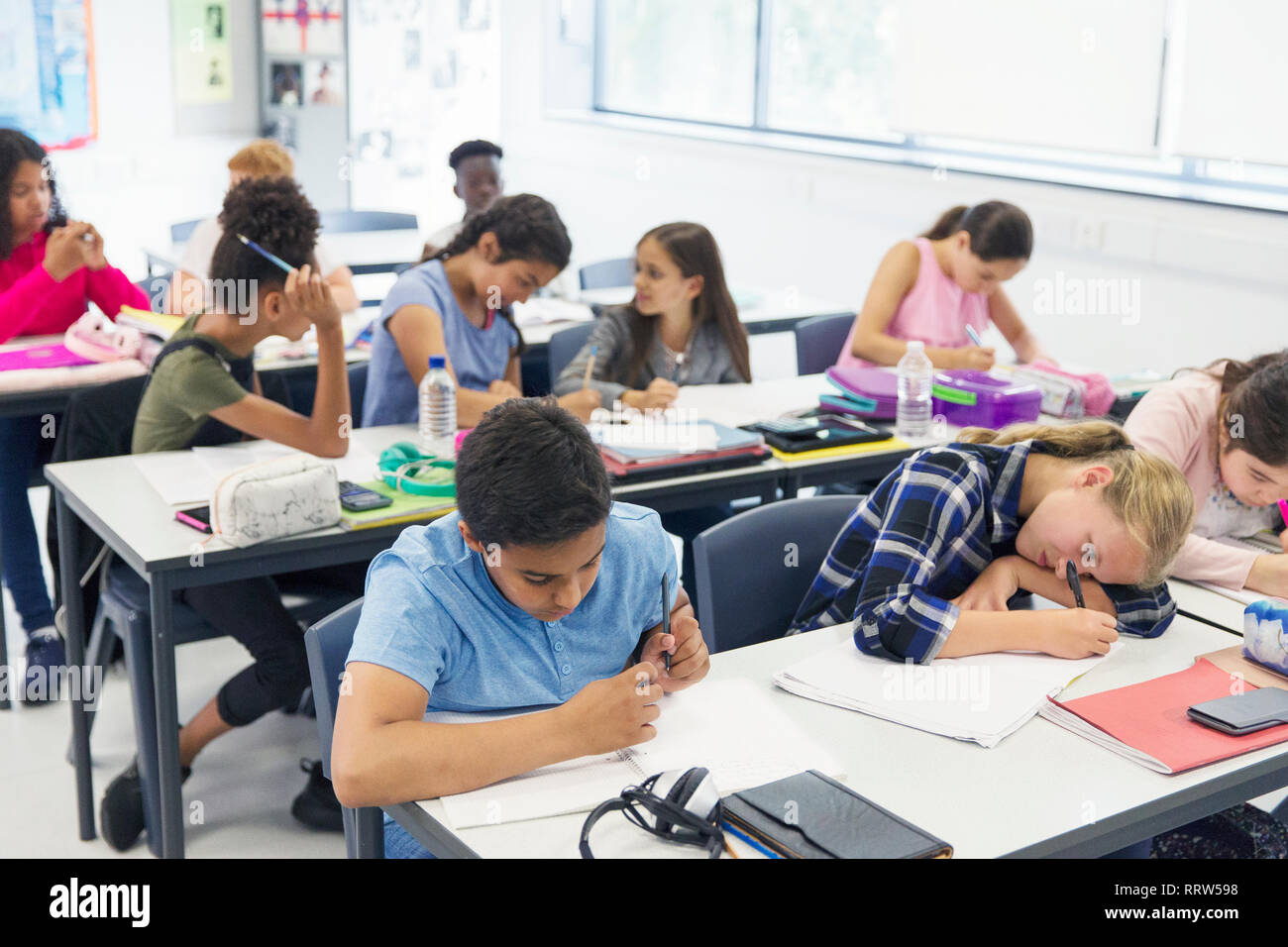 Junior high school students studying at desks in classroom Stock Photo