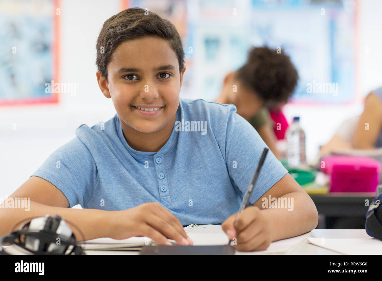 Portrait confident junior high school boy student doing homework in classroom Stock Photo