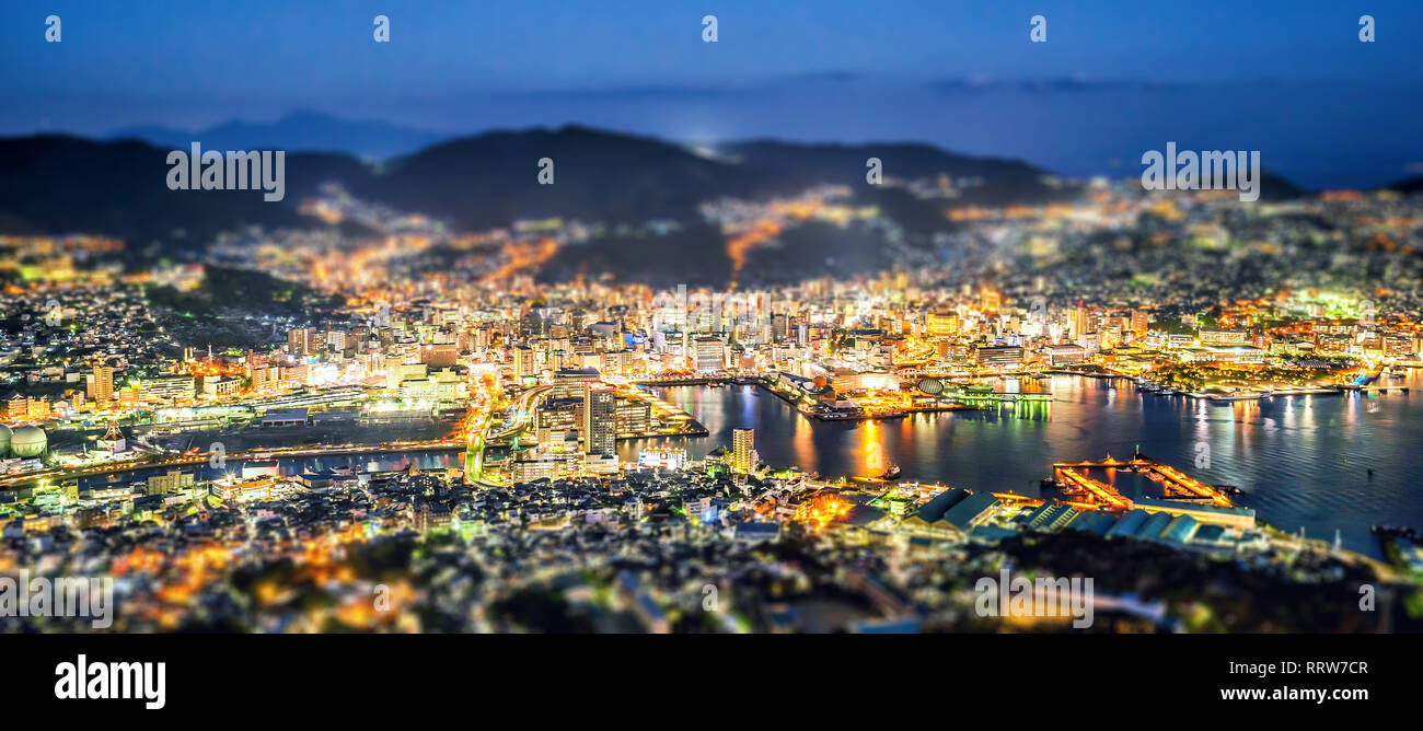 Business concept, tilt shift effect modern cityscape of nagasaki dusk from mount inasa, the new top 3 nightview of the world, aerial view, copy space Stock Photo