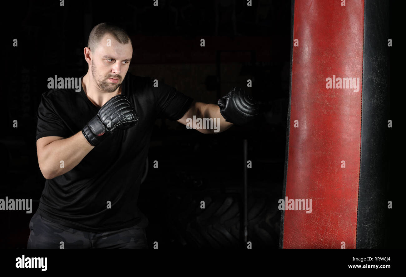 Boxer training on a punching bag in the gym Stock Photo