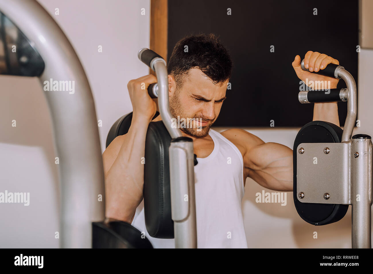 Closeup of a muscular young man, execute exercise in a gym. - Image Stock Photo