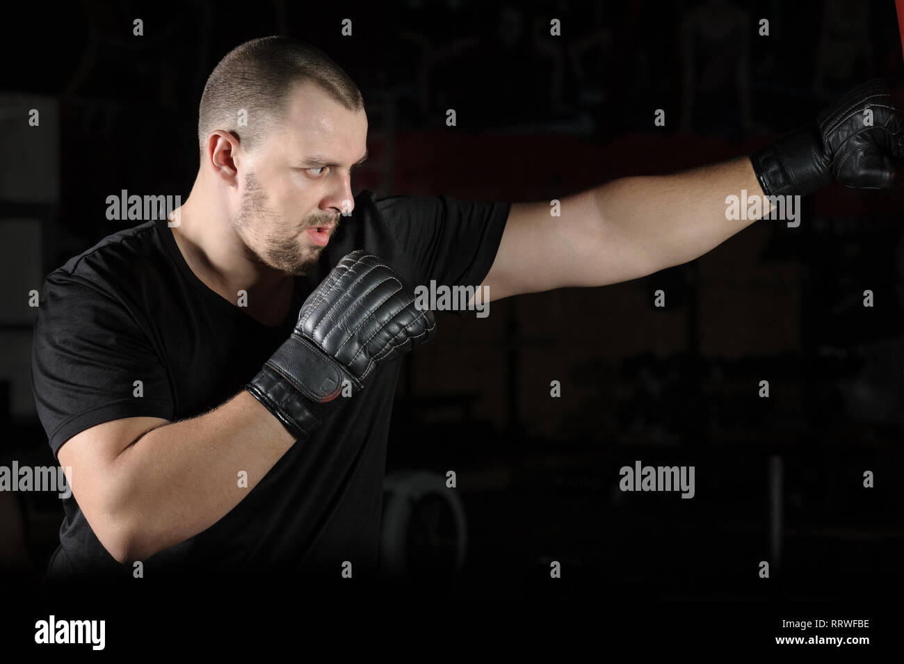 Boxer training on a punching bag in the gym Stock Photo