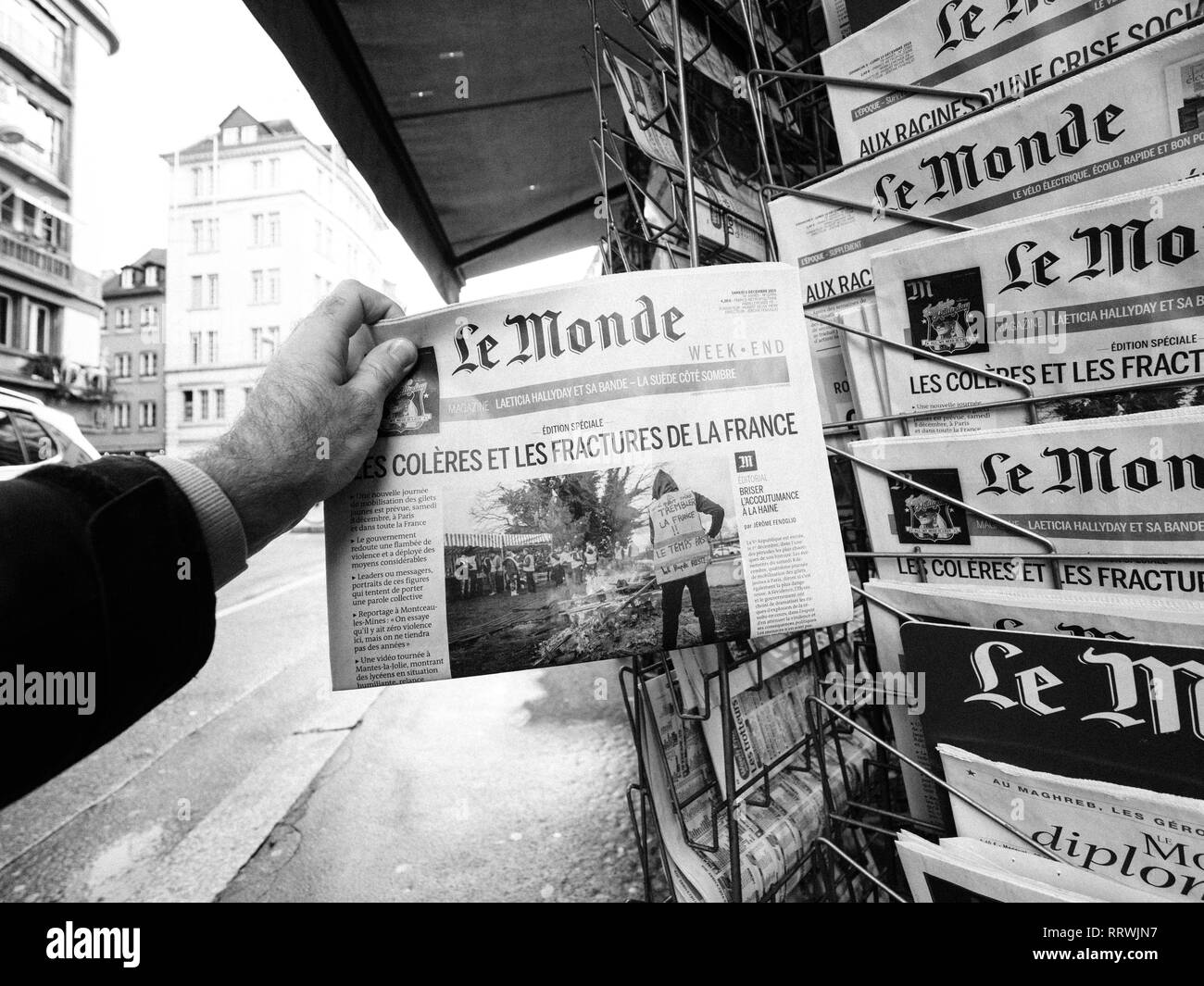 PARIS, FRANCE - DEC 10, 2018: Newspaper stand kiosk stand selling press  with male hand buying latest Le Monde featuring Gilets Jaunes Yellow  Jackets movements on front cover Stock Photo - Alamy