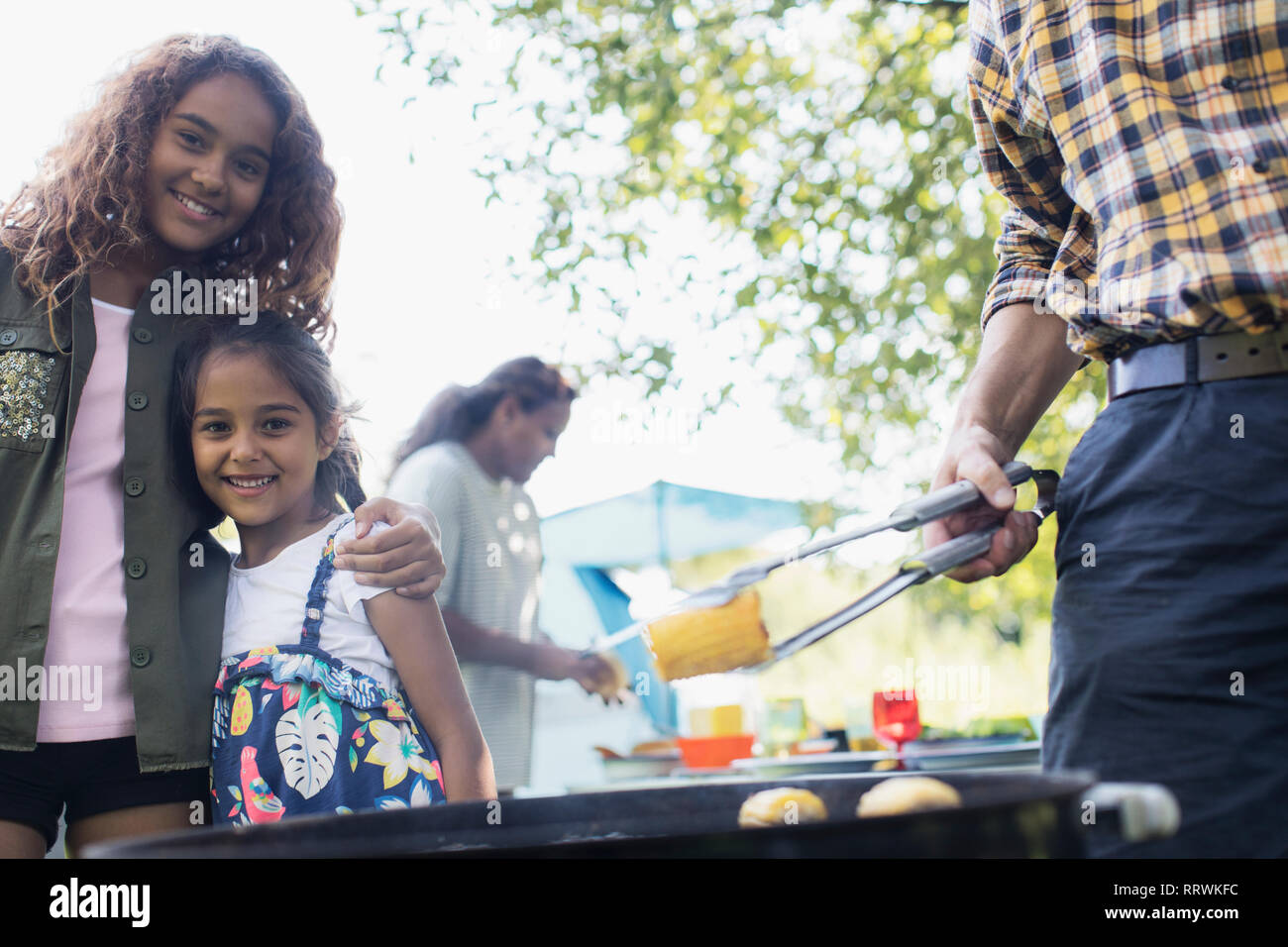 Portrait happy sisters enjoying backyard barbecue Stock Photo