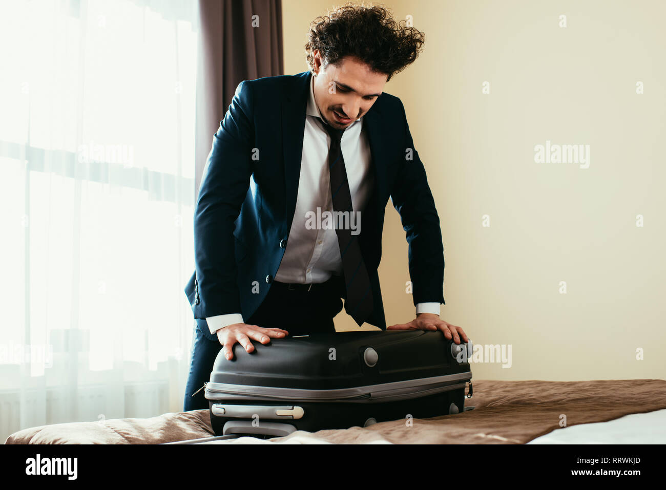 Suitcase on bed inside hotel hi-res stock photography and images - Alamy
