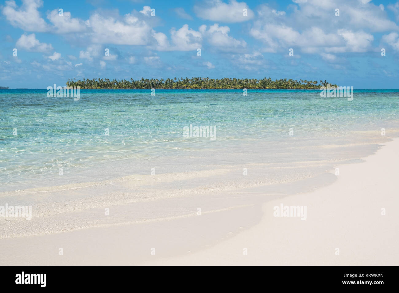 white sand beach with tropical palm tree island - Stock Photo