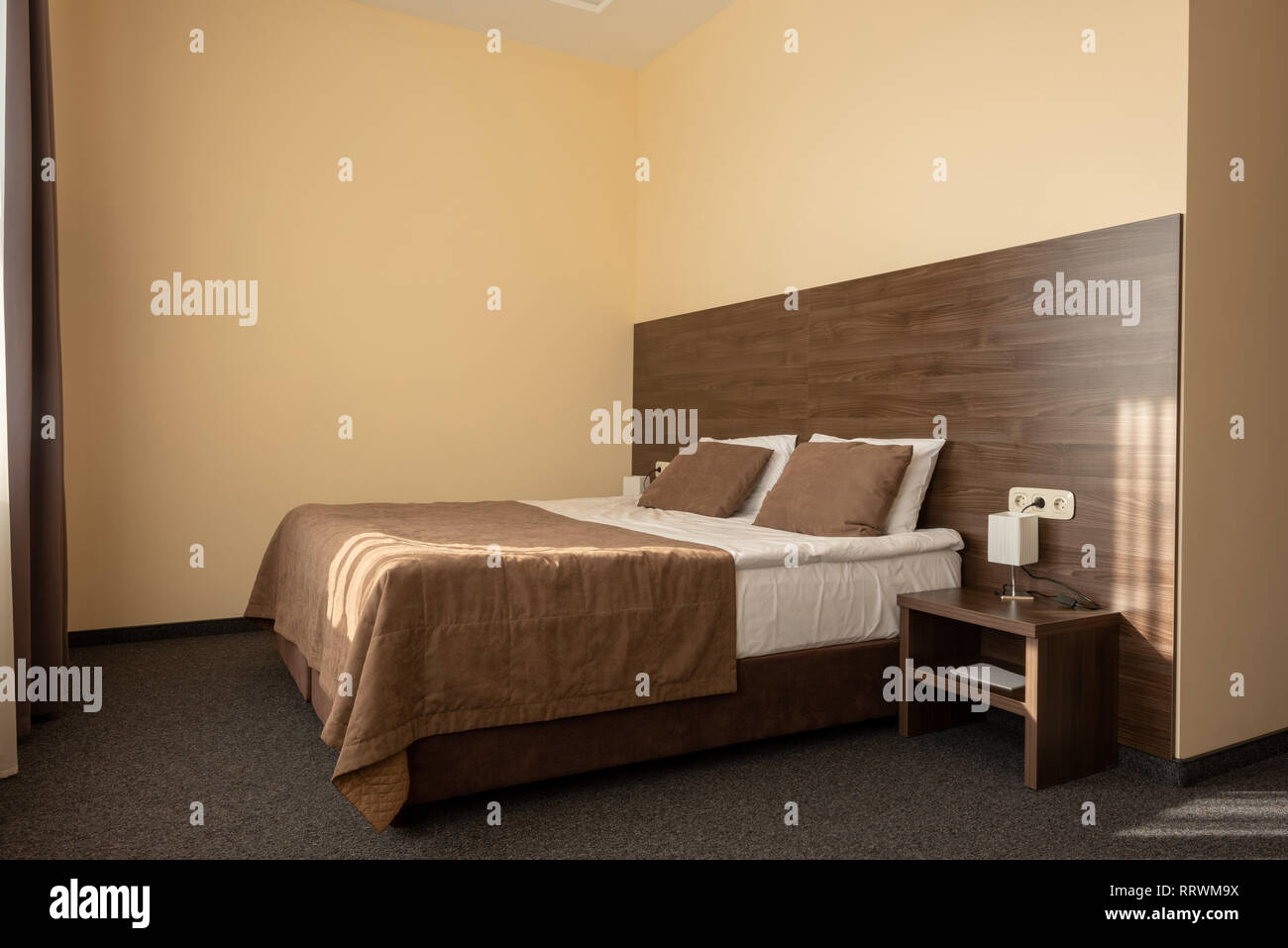 modern hotel bedroom interior with bed in brown color Stock Photo