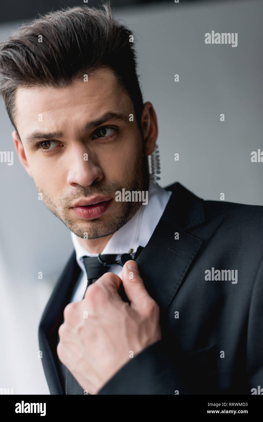 focused bodyguard in suit using microphone Stock Photo