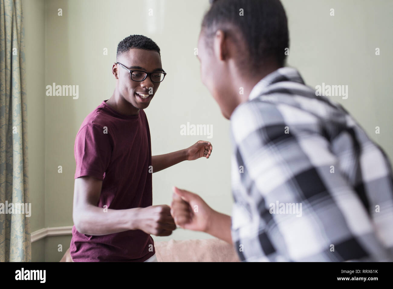 Teenage brothers doing secret handshake Stock Photo