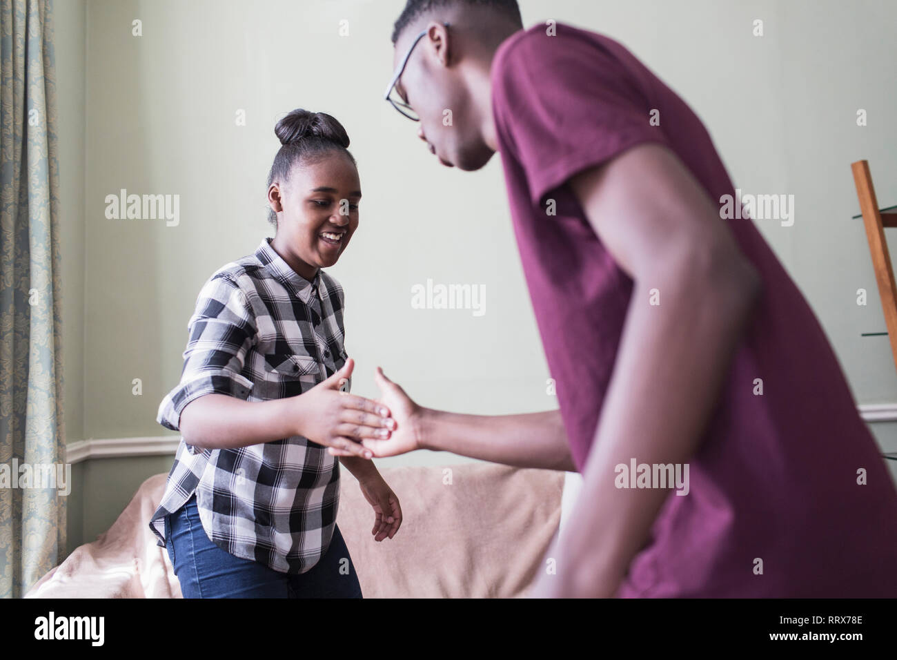Brother and sister doing secret handshake Stock Photo