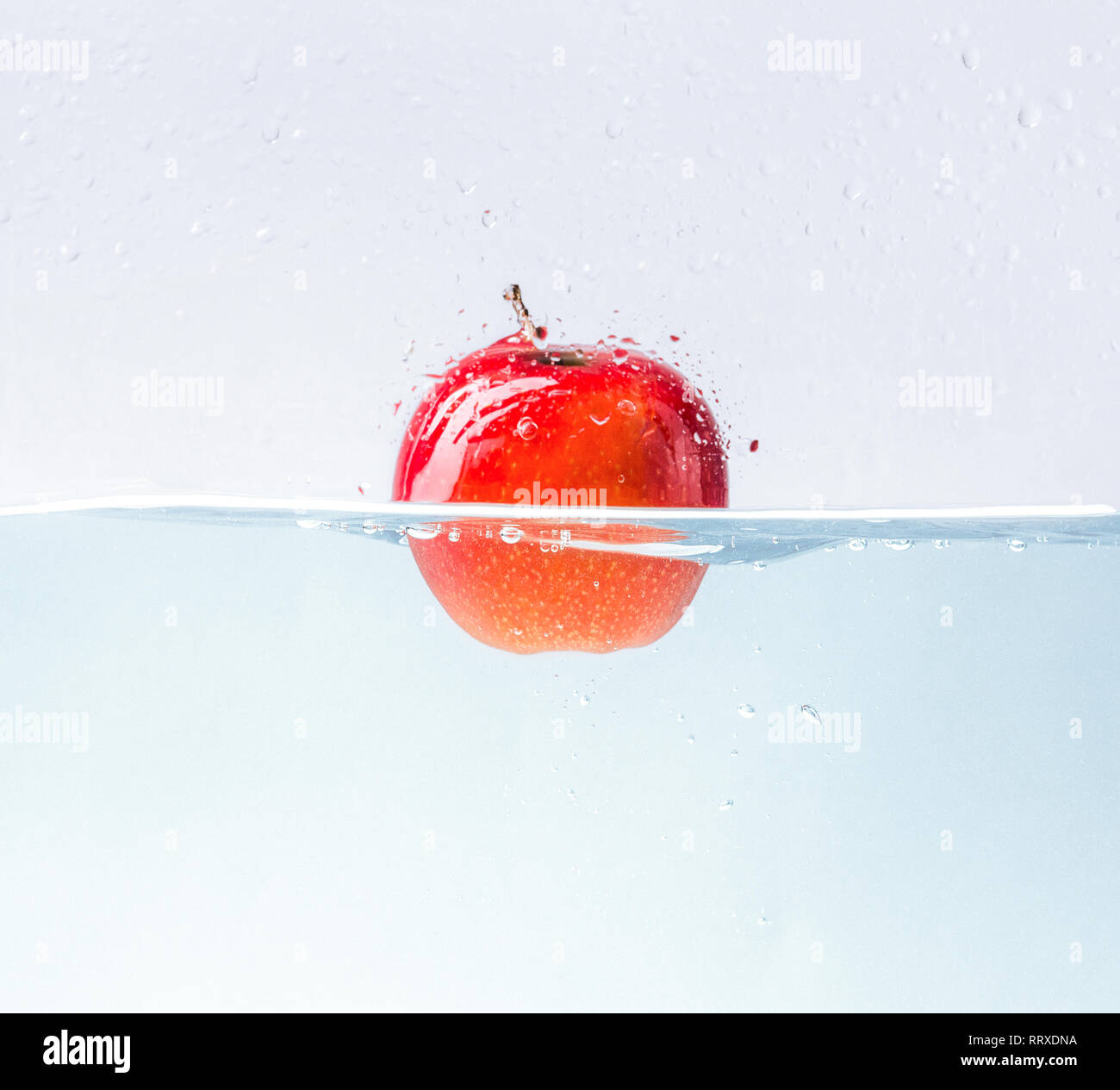 Apple with water splash on blue background Stock Photo