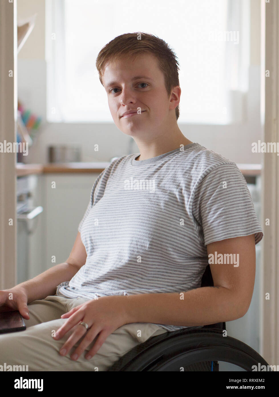 Portrait confident young woman in wheelchair at home Stock Photo