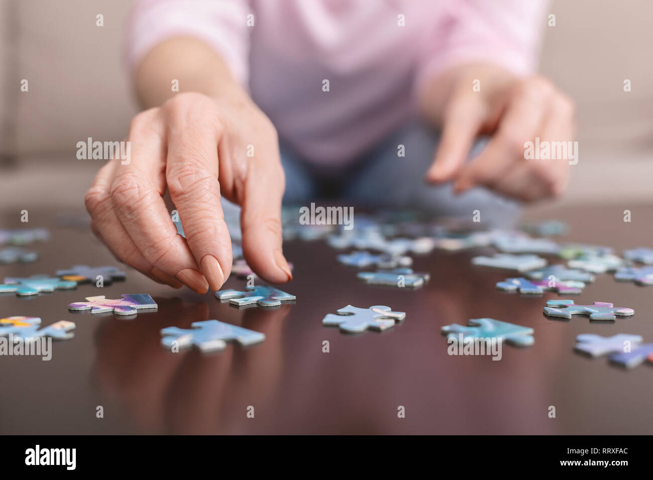 Senior woman doing jigsaw puzzle hires stock photography and images