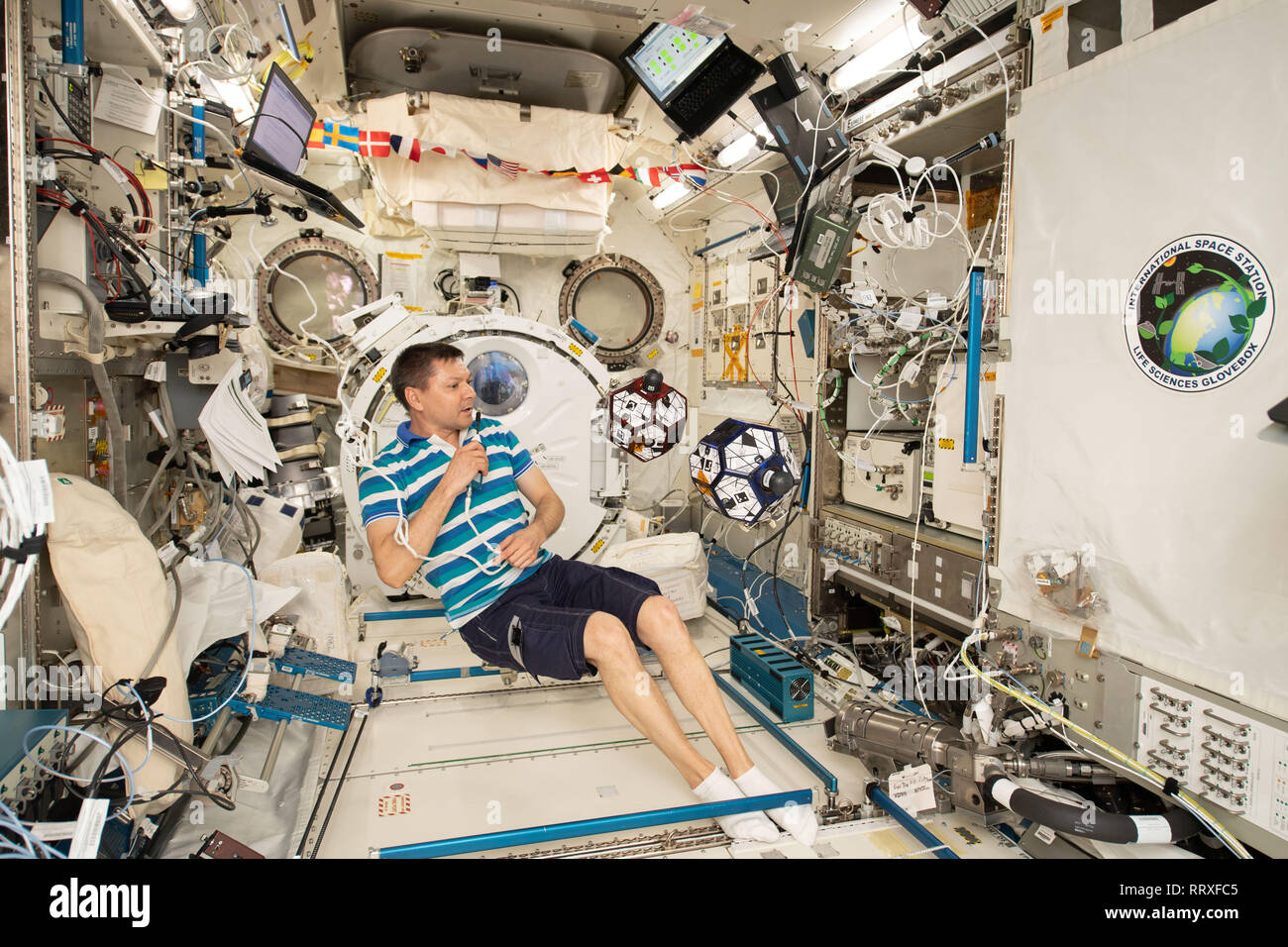 Commander Oleg Kononenko works inside the Japanese Kibo lab module monitoring a pair of tiny internal free-flying satellites known as SPHERES aboard the International Space Station January 14, 2019 in Earth Orbit. High school students compete to design the best algorithms that control the basketball-sized satellites to mimic spacecraft maneuvers and formation flying. Stock Photo