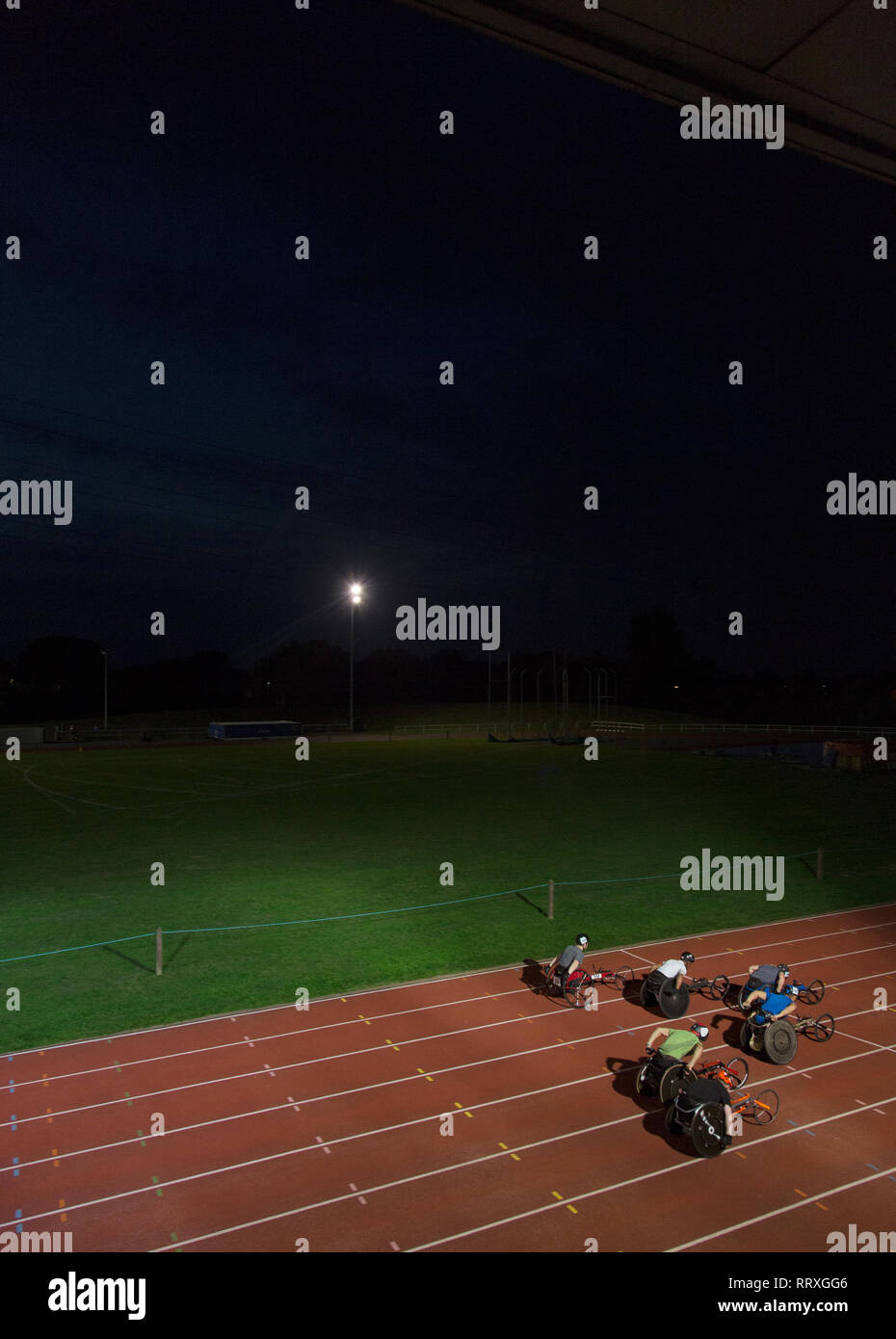 Paraplegic athletes speeding along sports track in wheelchair race at