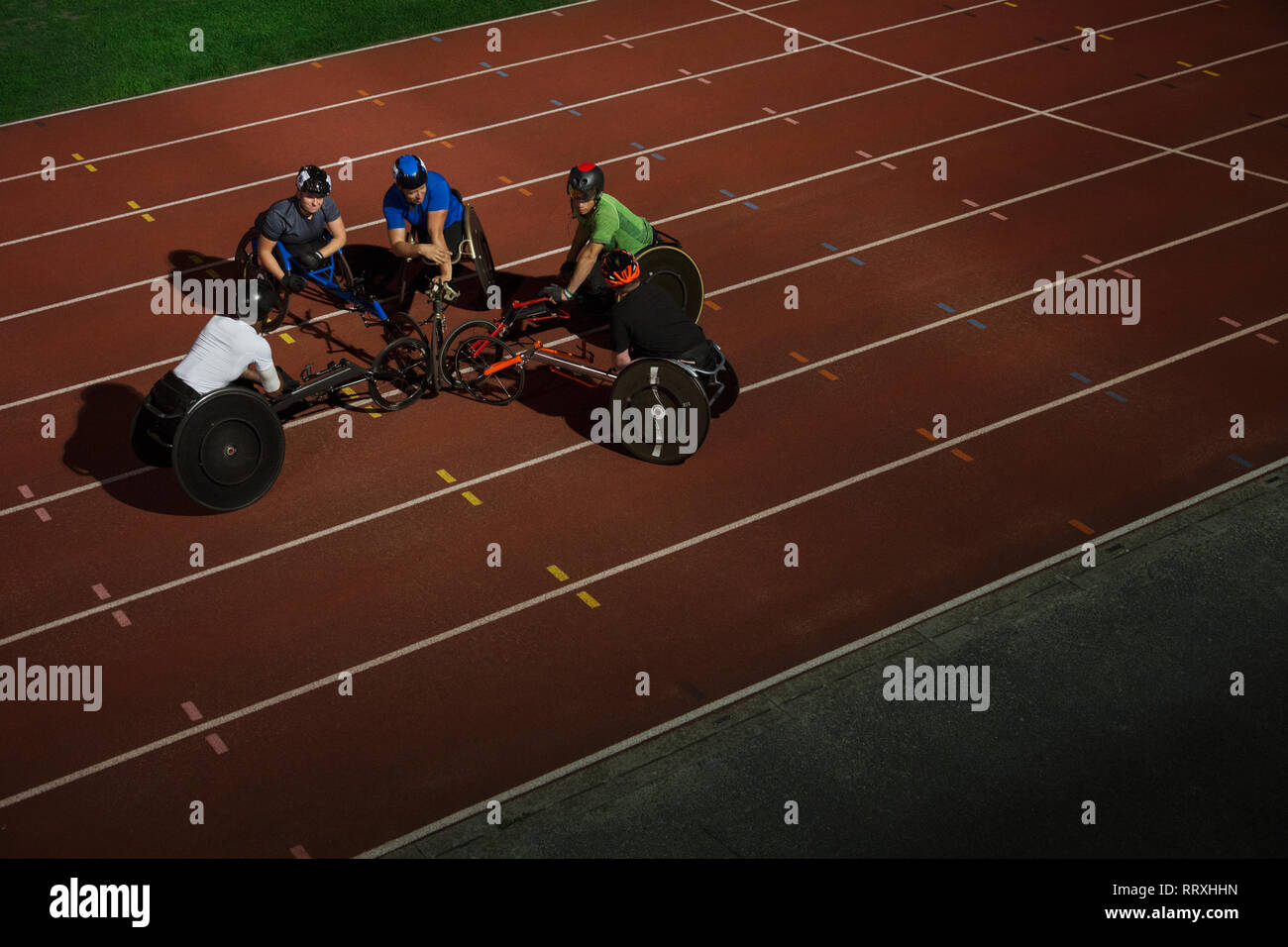 Paraplegic athletes huddling on sports track, training for wheelchair ...