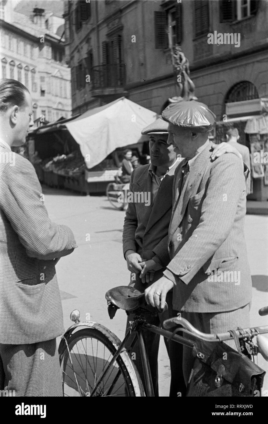 Bozen - Südtirol ca.1950, Männer auf dem Markt in Meran. Men talking to each other at the market of Merano, South Tyrol, Italy 1950s. Stock Photo