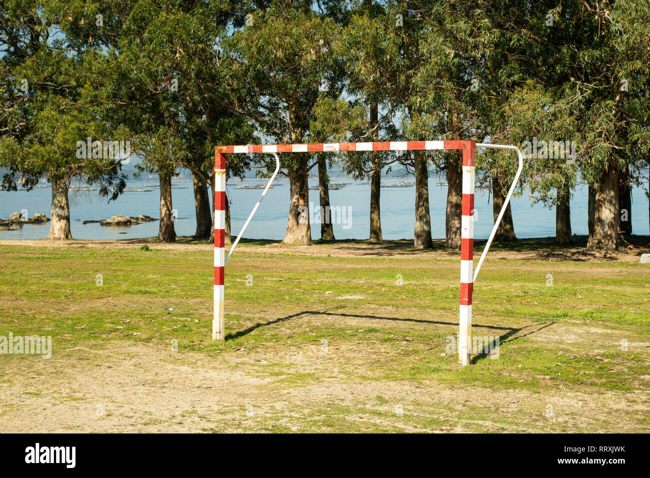 Soccer gate in amateur soccer court with trees and sea at background Stock Photo