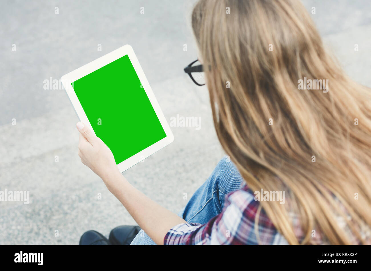 Young woman using tablet device with green screen Stock Photo