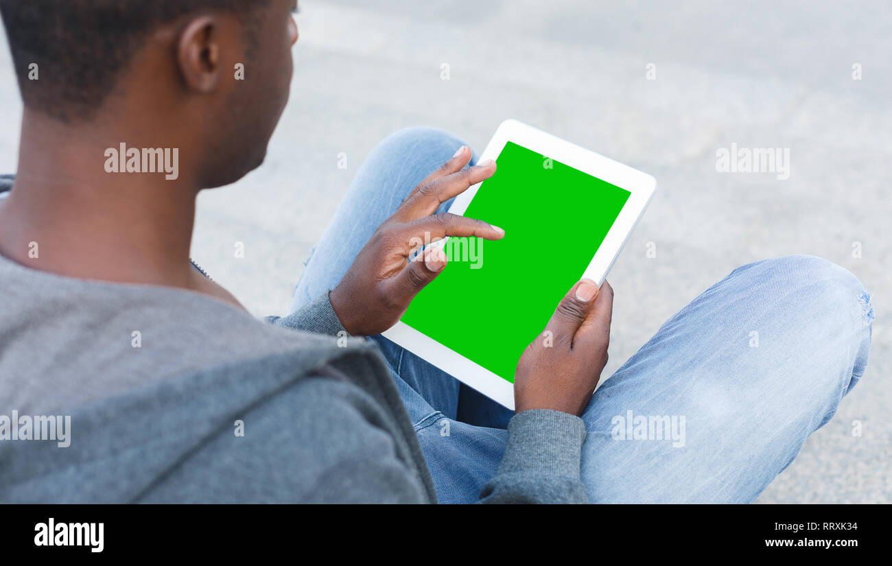 Young man using digital tablet pc with gree screen Stock Photo