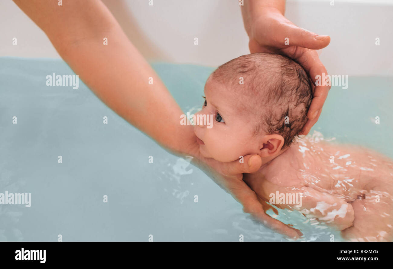 teaches infant baby to swim. Aquatic therapy for infant baby Stock Photo