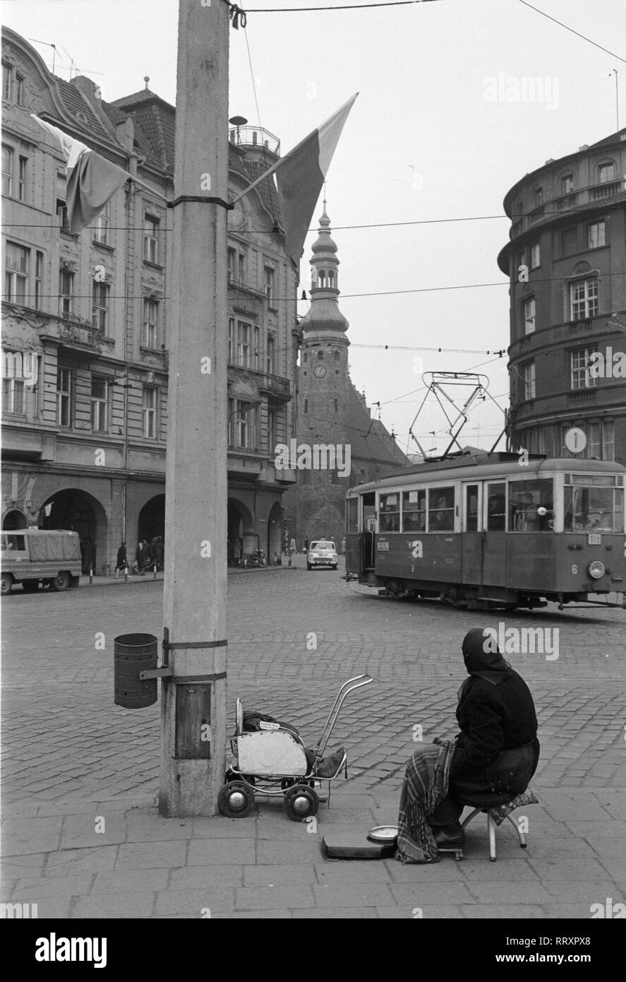 Poland - Polen ca. 1950, alte Frau sitzt auf der Kreuzung. A woman sitting by a crossroads when a tram passes by, ca. 1950. Stock Photo
