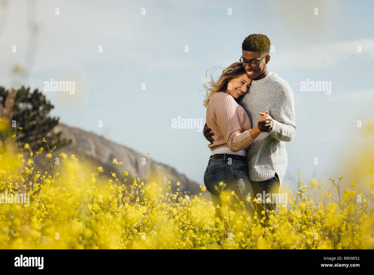 Happy couple dancing together outdoors. African man and caucasian woman enjoying a quality time together. Stock Photo