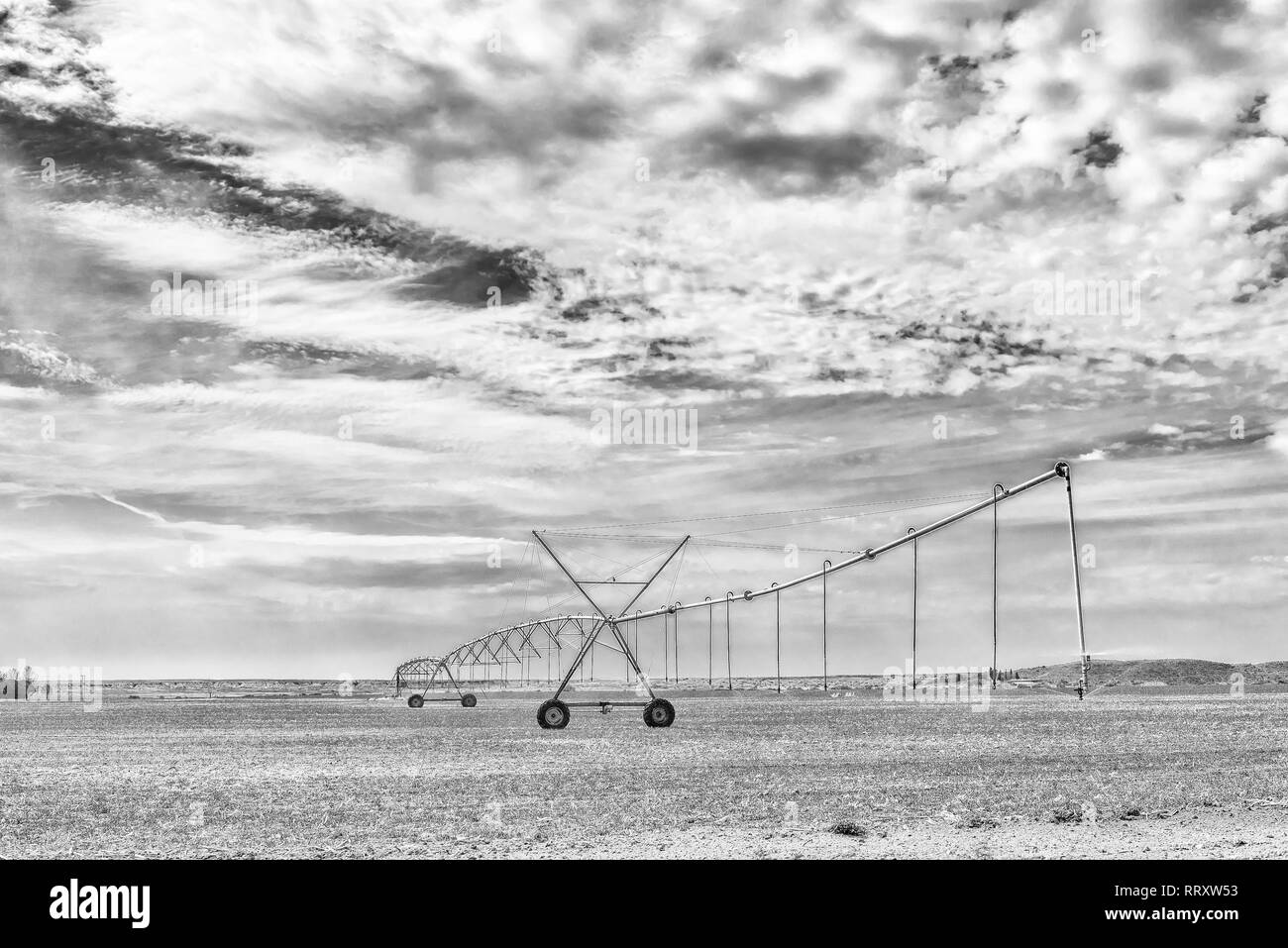 A center pivot irrigation system in operation near Orania in the Northern Cape Province. Monochrome Stock Photo