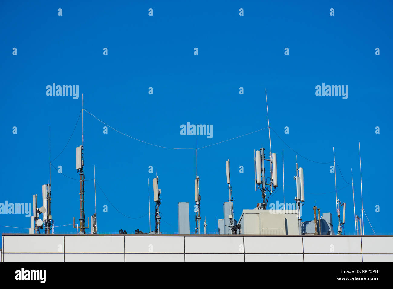 Panel antenna of GSM DCS UMTS LTE bands and radio unit are as part of communication equipment of basic station are installed on the roof of a building Stock Photo