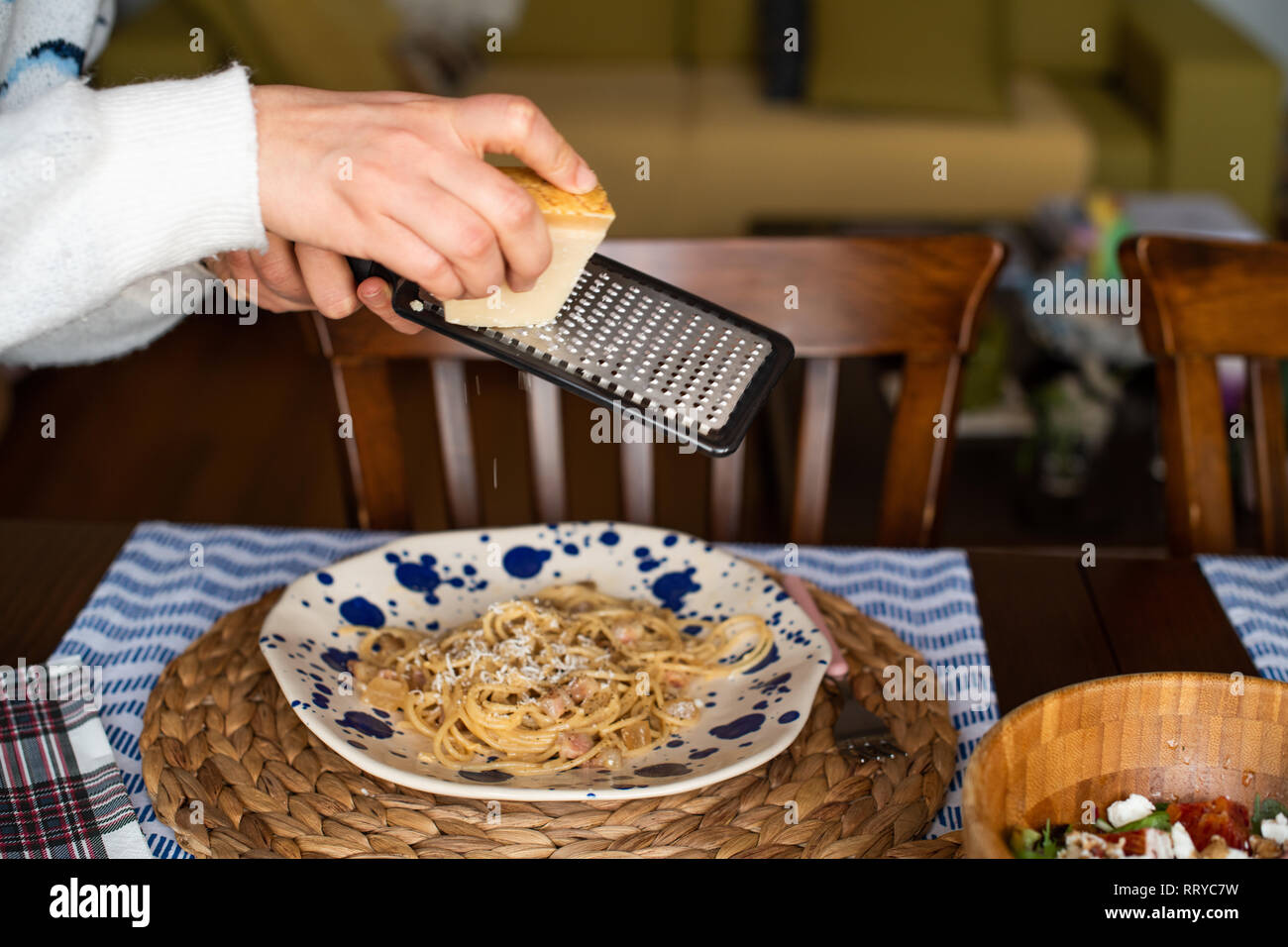 woman hands grating parmesan cheese on pasta carbonara Stock Photo Alamy