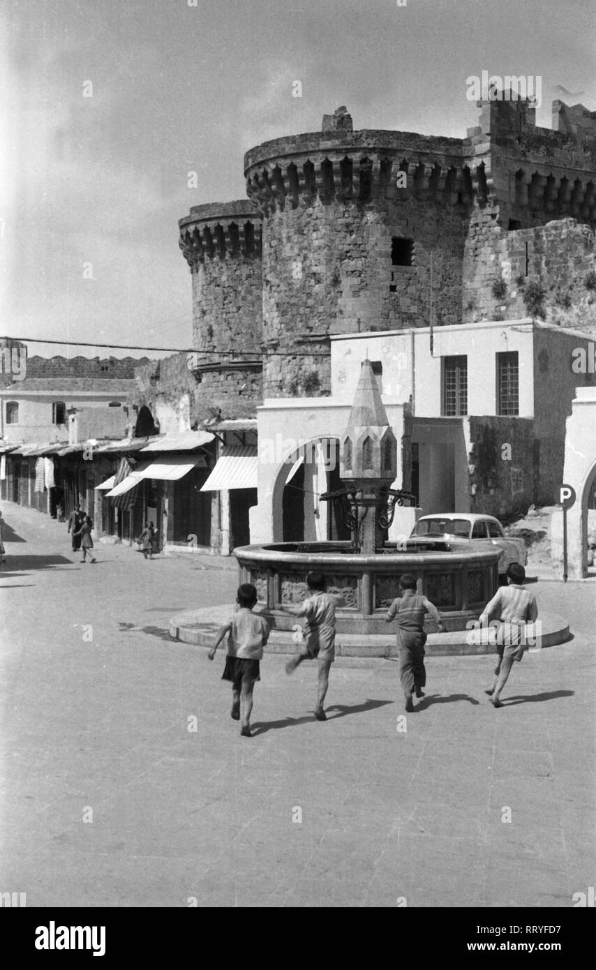Griechenland, Greece - Kinder rennen zum Spielen zu einem Brunnen auf Rhodos, Griechenland, 1950er Jahre. Children running to play on a fountain at Rhodes, Greece, 1950s. Stock Photo
