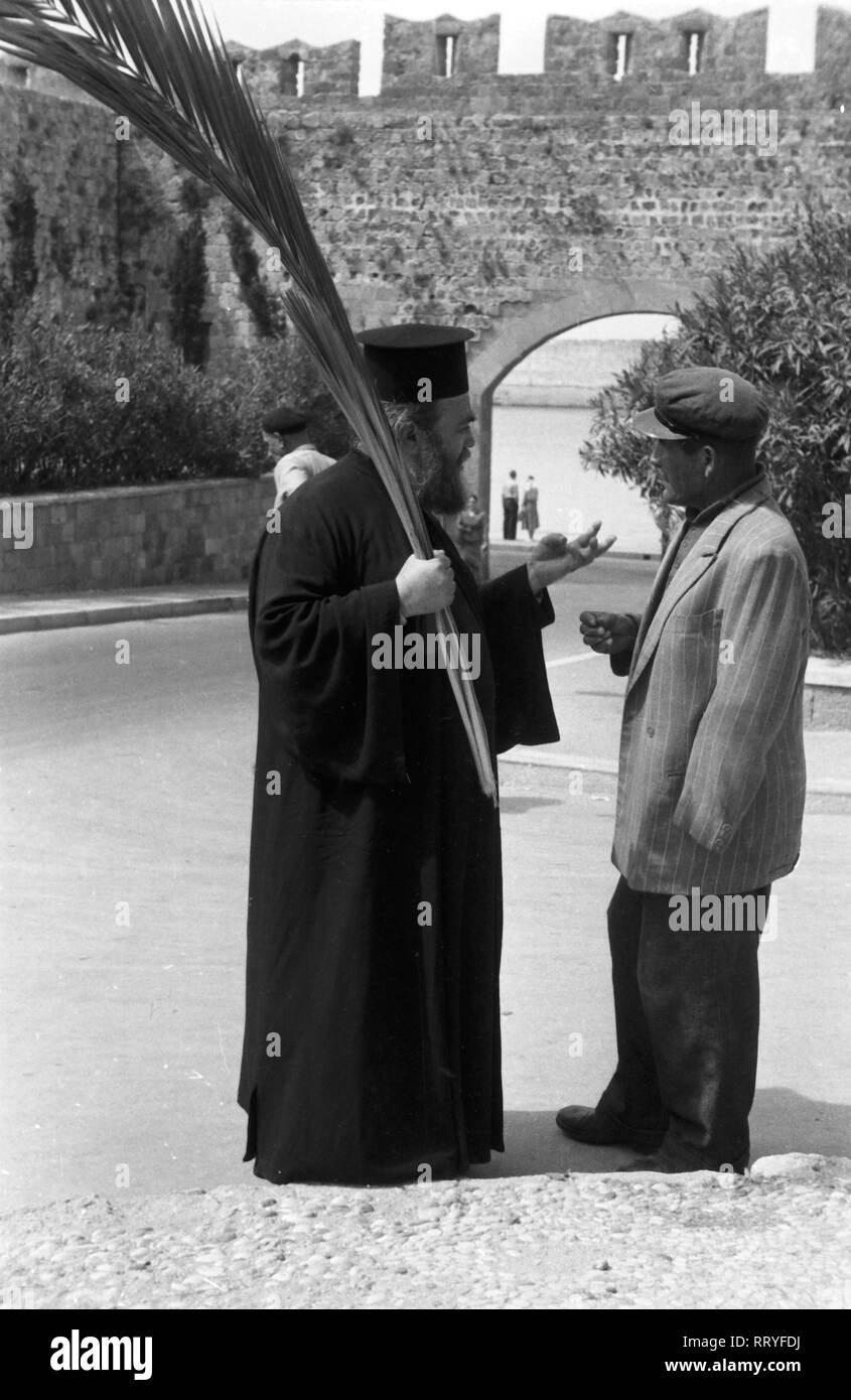 Griechenland, Greece - Ein Passant spricht - wahrscheinlich am Palmsonntag - mit einem Geistlichen auf Rhodos, Griechenland, 1950er Jahre. A man talking to a clergyman - maybe Palm Sunday - on Rhodos, Greece 1950s. Stock Photo
