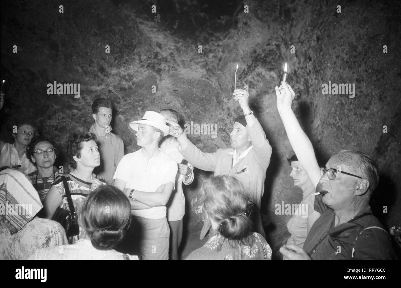 Griechenland, Greece - Eine Touristengruppe bekommt mit Kerzen als Beleuchtung ausgerüstet, das Innere des Schatzhauses des Atreus erläutert, Griechenland 1950er Jahre. A group of tourists with candles going inside the treasury of Atreus in Greece, 1950s. Stock Photo