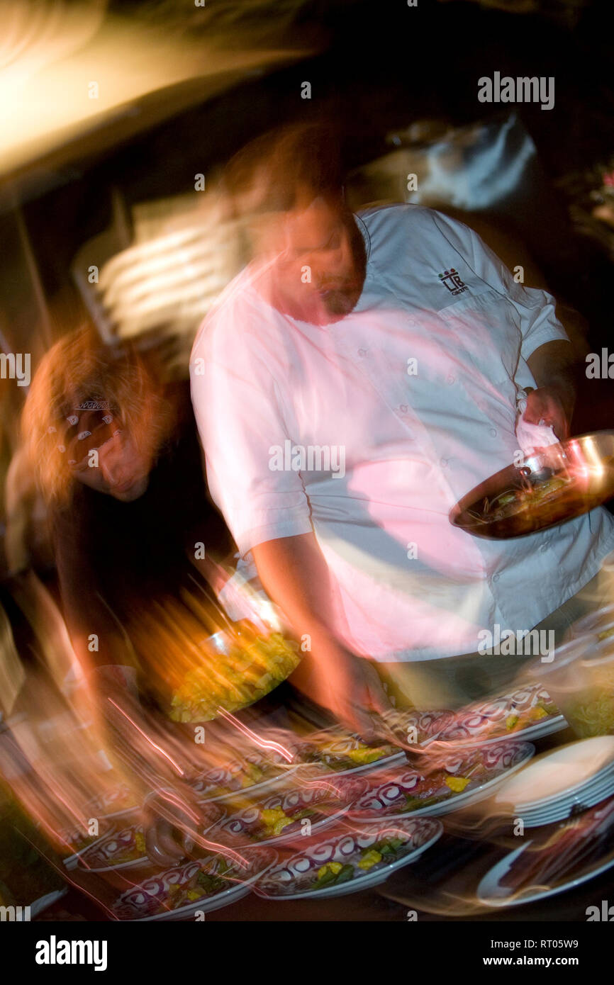A time lapse view of a chef preparing a meal in the kitchen. Stock Photo