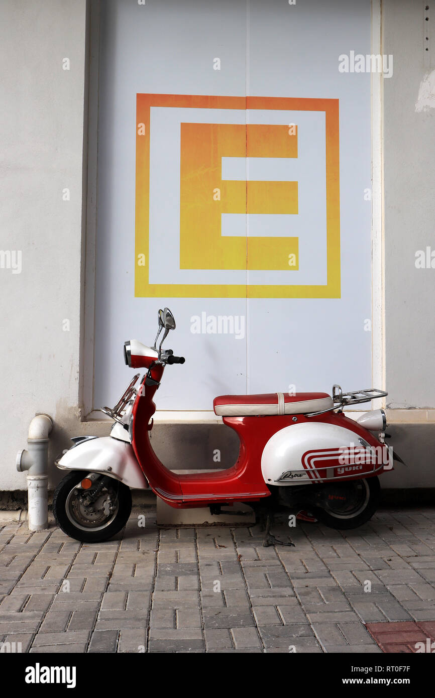 Retro scooter parked under the big letter E Stock Photo
