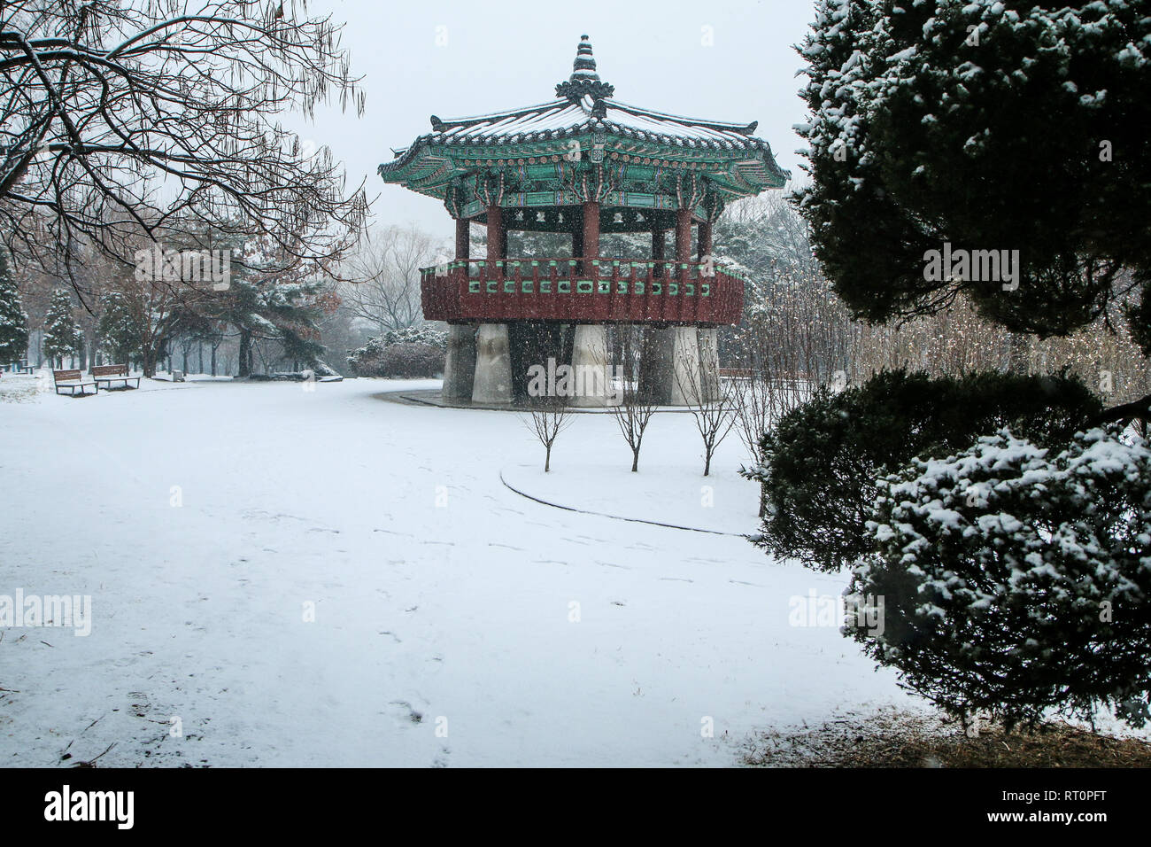 A Picture from the Yeouido park in Seoul in South Korea during the cold winter day and a snowfall. You can see one of the traditional wooden pavilions Stock Photo