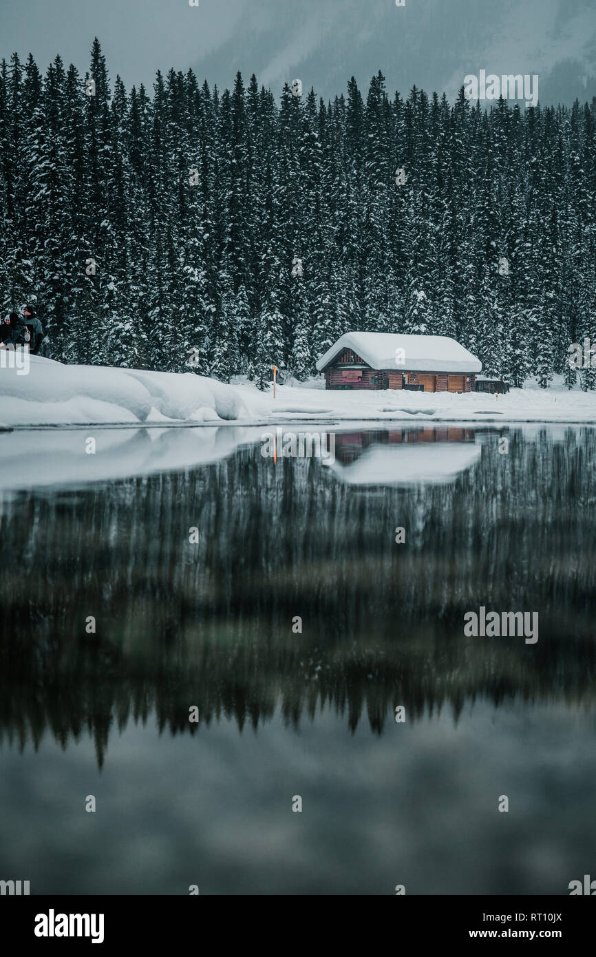 Winter mountain reflection in the calm clear water at Lake Louise in Banff National Park, Alberta, Canada Stock Photo