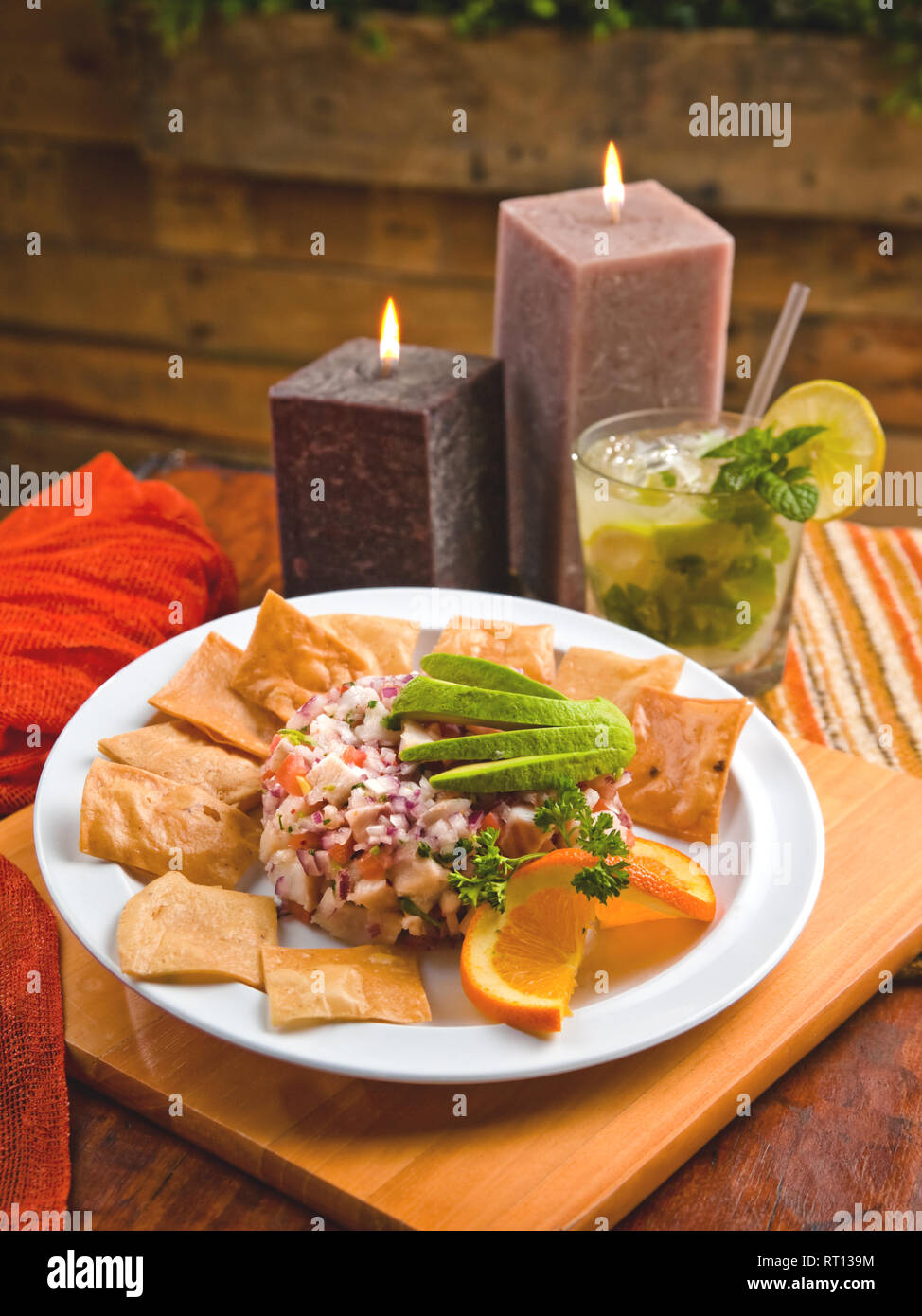 Fish ceviche with avocado, tortilla chips and a mojito Stock Photo