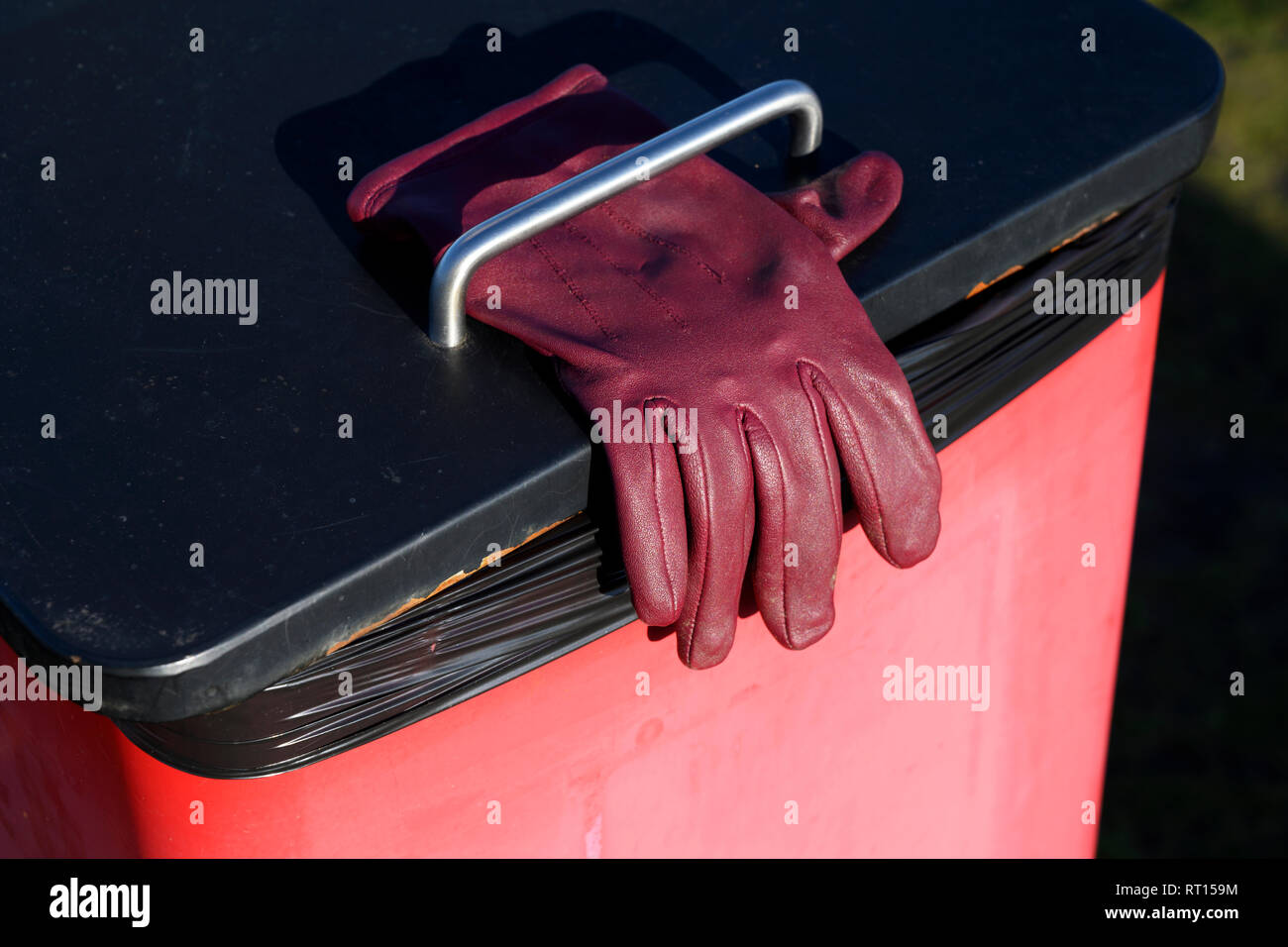 Ladies red leather glove left on top of litter bin, Sutton Heath, Suffolk, UK. Stock Photo