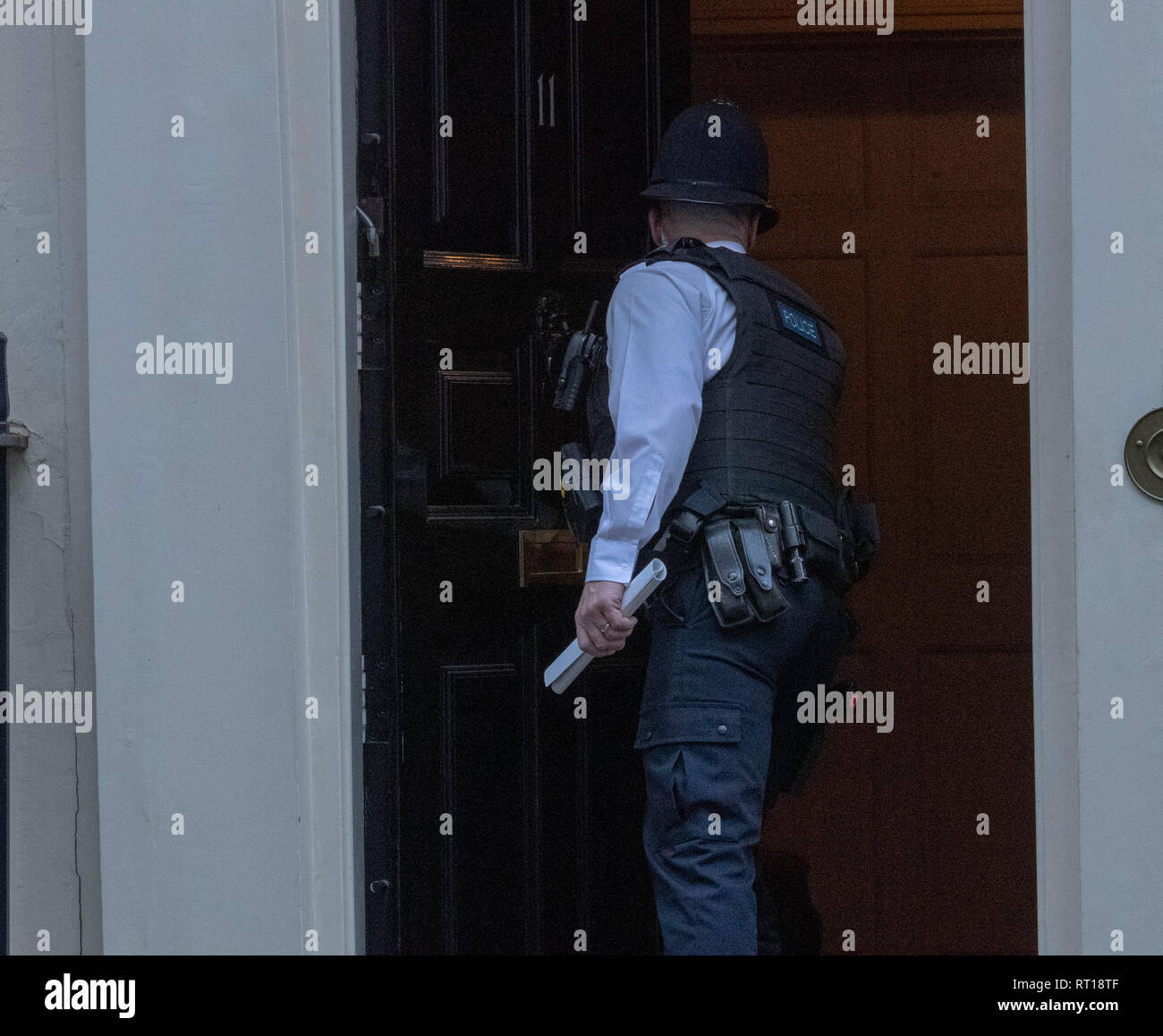 London, UK. 27th Feb 2019. A policeman closes the door of 11 Downing Street after it was left open when Phillip Hammond left Credit: Ian Davidson/Alamy Live News Stock Photo