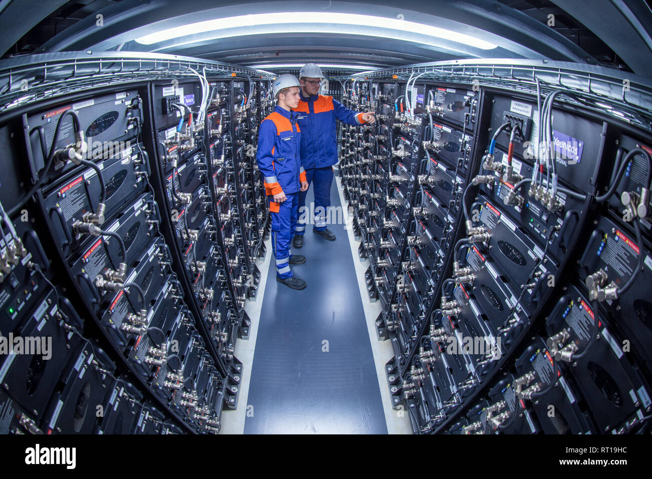 25 February 2019, Mecklenburg-Western Pomerania, Schwerin: The trainees Florian Maty (front) Tom Hoffmann are standing in the battery storage of the energy supplier WEMAG. The skilled workers initiative 'Take off in MV' is launching a new campaign to improve the skilled workers situation in Mecklenburg-Western Pomerania. Photo: Jens Büttner/dpa-Zentralbild/ZB Stock Photo