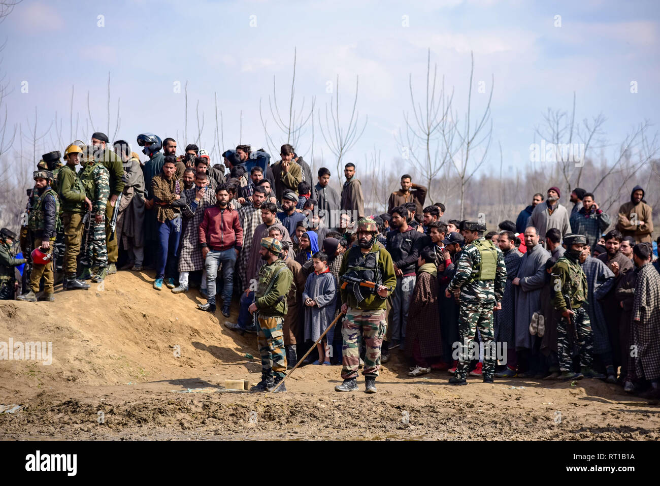 Budgam, Jammu and Kashmir, India. 27th Feb, 2019. Indian army men are seen standing on guard as the kashmiri villagers gathered near the wreckage of an aircraft that crashed in Budgam area.A civilian and six Indian Air Force personnel were killed after a Mi-17 chopper crashed near Garend Kalan village in Budgam which is some 30 Kms from Summer Capital Srinagar Kashmir. Credit: Idrees Abbas/SOPA Images/ZUMA Wire/Alamy Live News Stock Photo