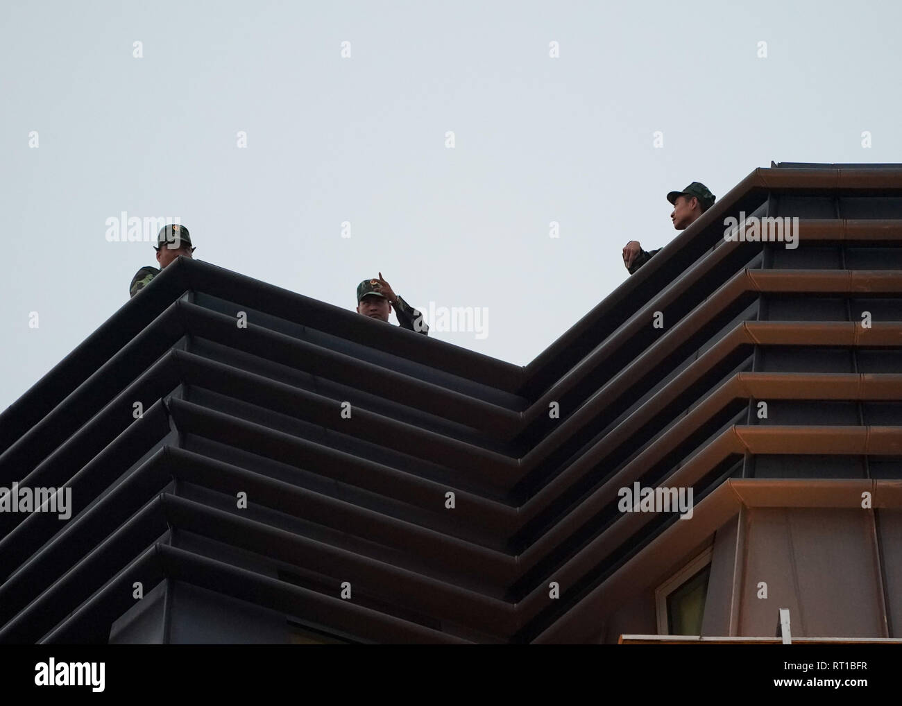 Hanoi, Vietnam. 27th Feb, 2019. February 27, 2019 - Hanoi, Vietnam - Security personnel stand guard on a rooftop next to a the street leading to the Sofitel Legend Metropole hotel where North Korean Leader Kim Jong Un and U.S. President Donald Trump met for dinner during the second North Korea-U.S. Summit in the capital city of Hanoi, Vietnam. Credit: Christopher Jue/ZUMA Wire/Alamy Live News Stock Photo