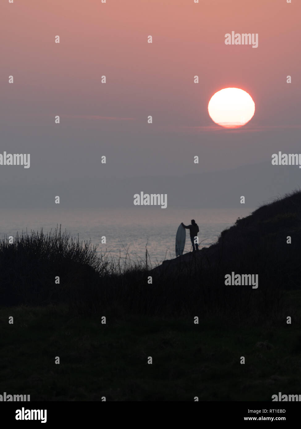 Pembrokeshire, Wales, UK. 27th February, 2019. Last day on the waves as the sun sets and hot weather ends at Manorbier Beach, Pembrokeshire West Wales UK Wednesay 27th February 2019 Credit: dayslikethis/Alamy Live News Stock Photo