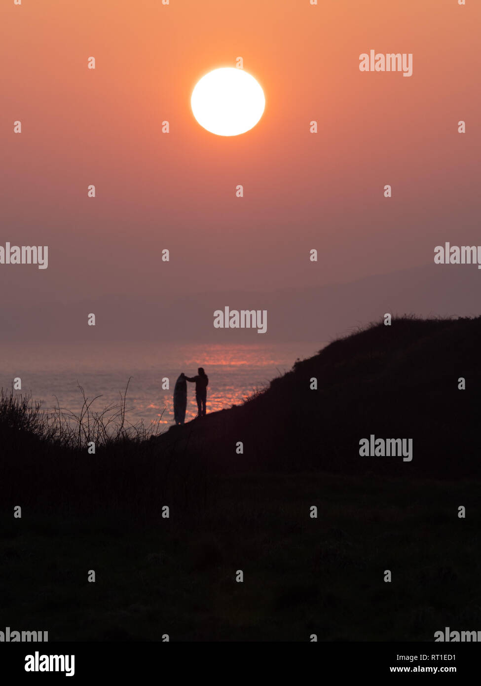 Pembrokeshire, Wales, UK. 27th February, 2019. Last day on the waves as the sun sets and hot weather ends at Manorbier Beach, Pembrokeshire West Wales UK Wednesay 27th February 2019 Credit: dayslikethis/Alamy Live News Stock Photo