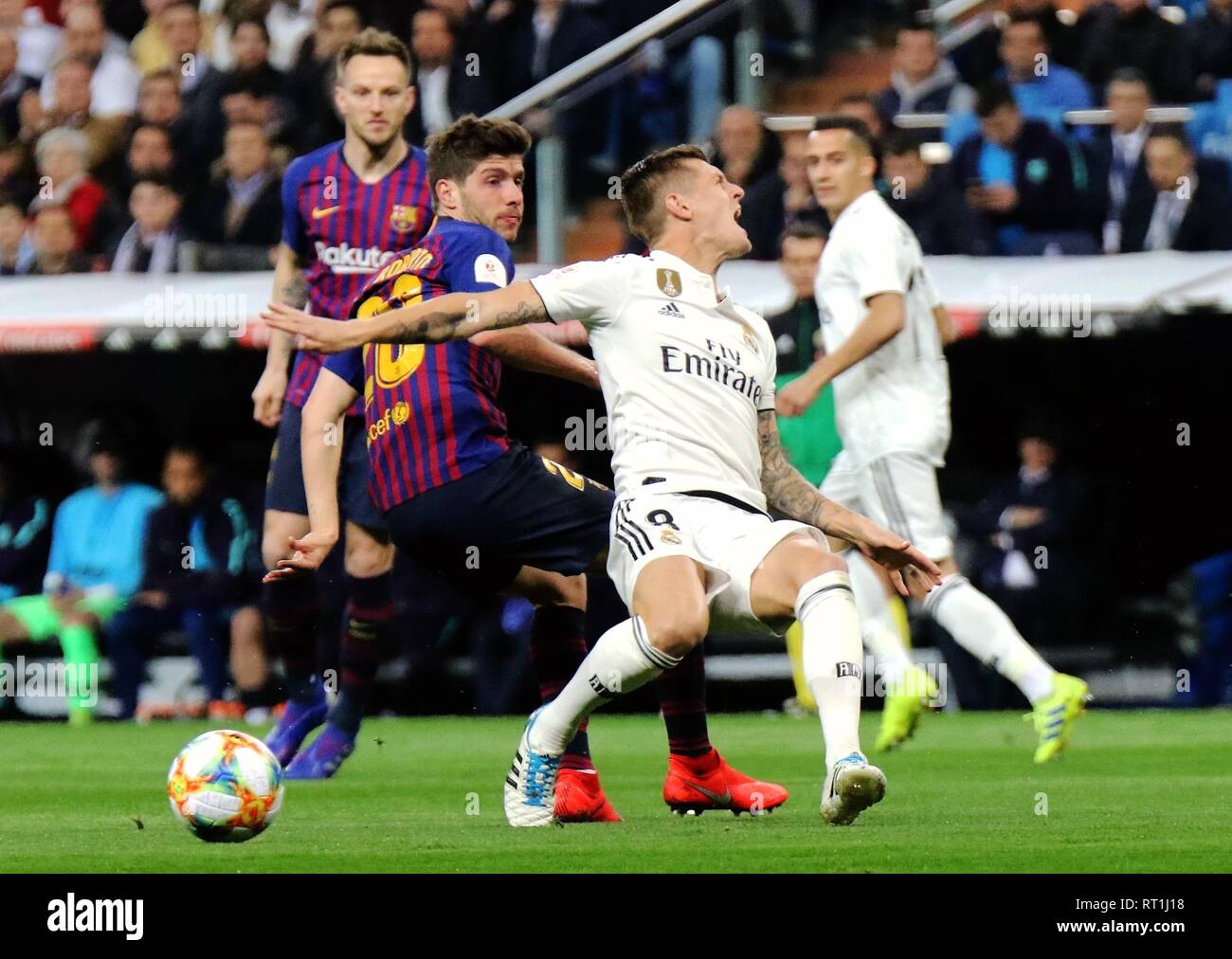 Madrid. 27th Feb, 2019. Real Madrid's Toni Kroos (2nd R) competes with Barcelona's Sergi Roberto (2nd L) during the Spanish King's Cup semifinal second leg soccer match between Real Madrid and Barcelona in Madrid, Spain on Feb. 27, 2019. Real Madrid lost 0-3. Credit: Edward F. Peters/Xinhua/Alamy Live News Stock Photo