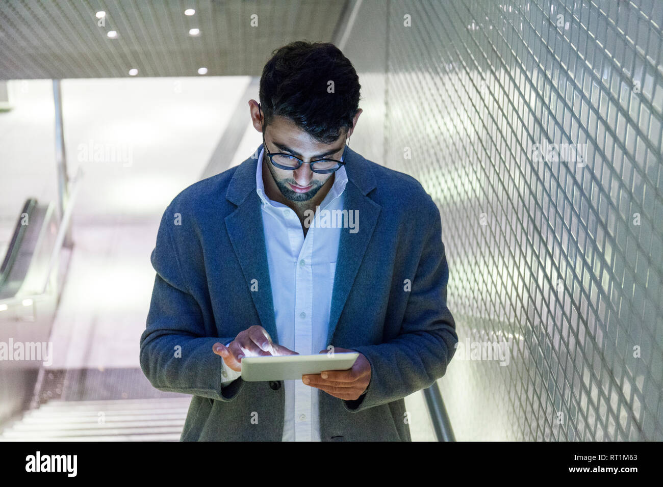 Young businessman standing on stairs using digital tablet Stock Photo