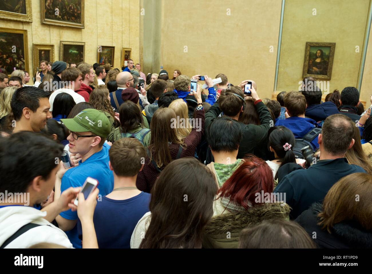 PARIS, FRANCE - APRIL 3, 2015: Tourists photographing the famous picture of Gioconda in Louvre Museum. Stock Photo