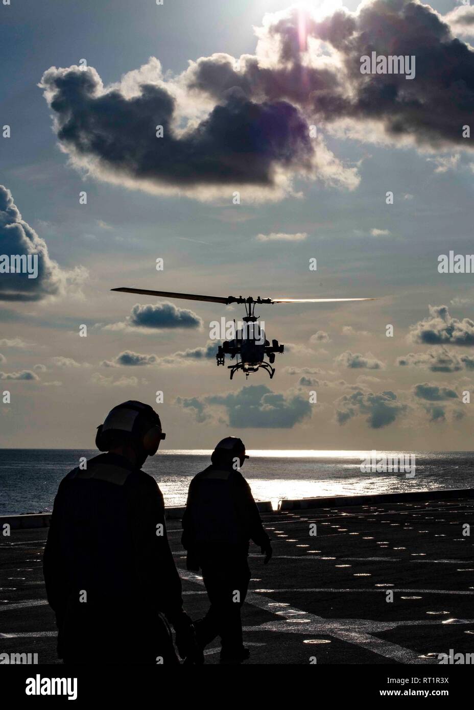 190221-N-HG389-0025 MEDITERRANEAN SEA (Feb. 21, 2019) An AH-1W Super Cobra helicopter assigned to the “Black Knights” of Marine Medium Tiltrotor Squadron (VMM) 264 (Reinforced) prepares to land on the flight deck of the San Antonio-class amphibious transport dock ship USS Arlington (LPD 24), Feb. 21, 2019. Arlington is on a scheduled deployment as part of the Kearsarge Amphibious Ready Group in support of maritime security operations, crisis response and theater security cooperation, while also providing a forward naval presence. (U.S. Navy photo by Mass Communication Specialist 2nd Class Bran Stock Photo