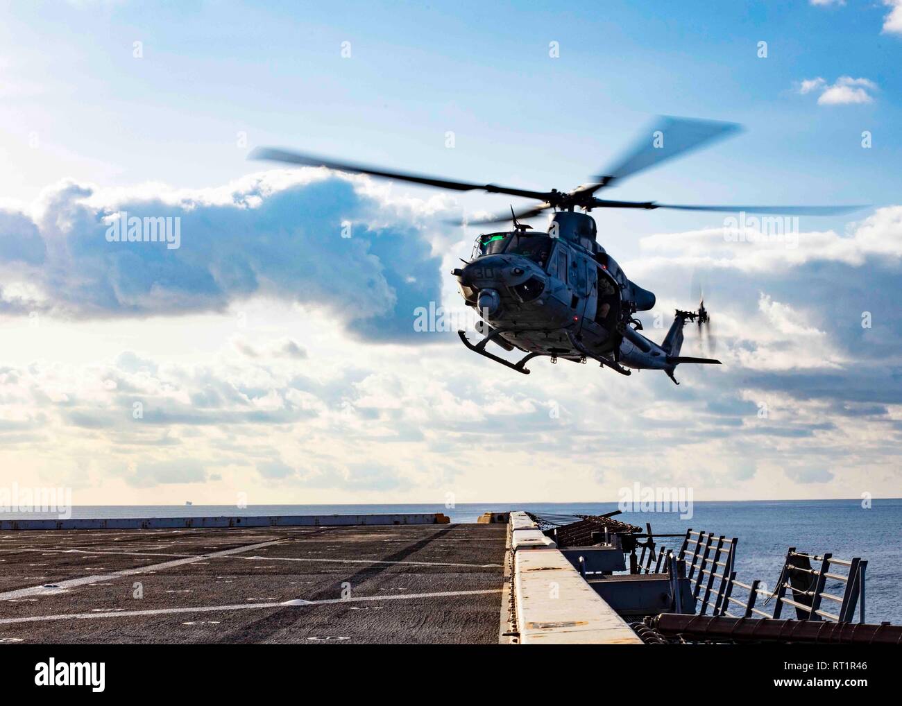 190221-N-HG389-0084 MEDITERRANEAN SEA (Feb. 21, 2019) A UH-1Y Huey helicopter assigned to the “Black Knights” of Marine Medium Tiltrotor Squadron (VMM) 264 (Reinforced) prepares to land on the flight deck of the San Antonio-class amphibious transport dock ship USS Arlington (LPD 24), Feb. 21, 2019. Arlington is on a scheduled deployment as part of the Kearsarge Amphibious Ready Group in support of maritime security operations, crisis response and theater security cooperation, while also providing a forward naval presence. (U.S. Navy photo by Mass Communication Specialist 2nd Class Brandon Park Stock Photo